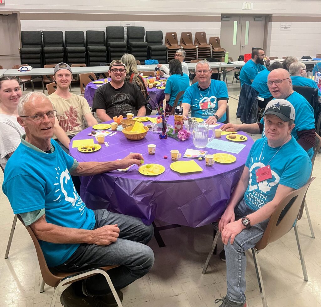 Guests and volunteers in blue shirts at a Friendship ministry celebration