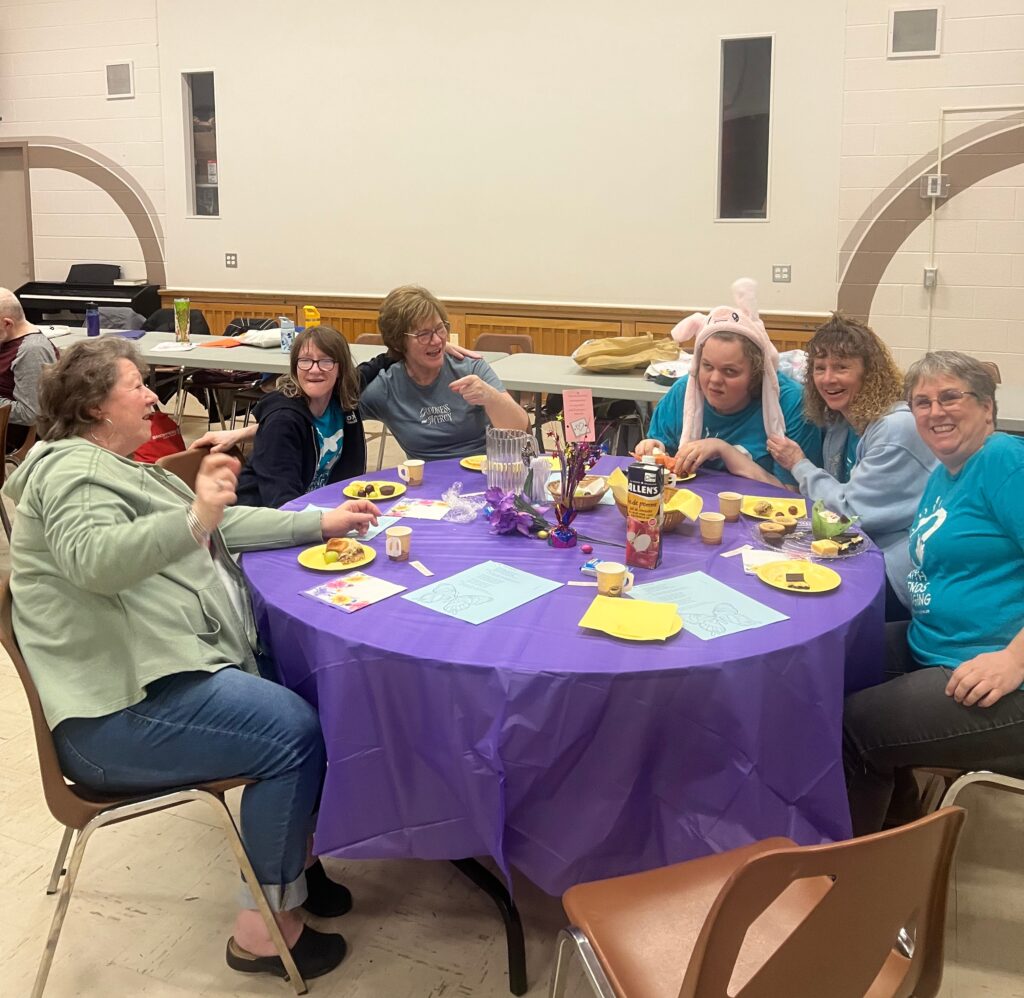 Guests seated at a decorated table during a Friendship ministry celebration